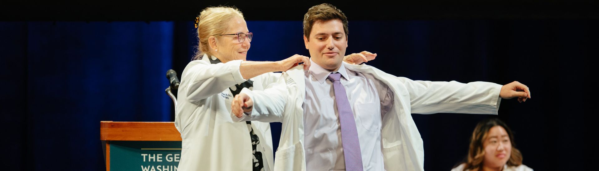 Student Receiving his White Coat from Dean Bass